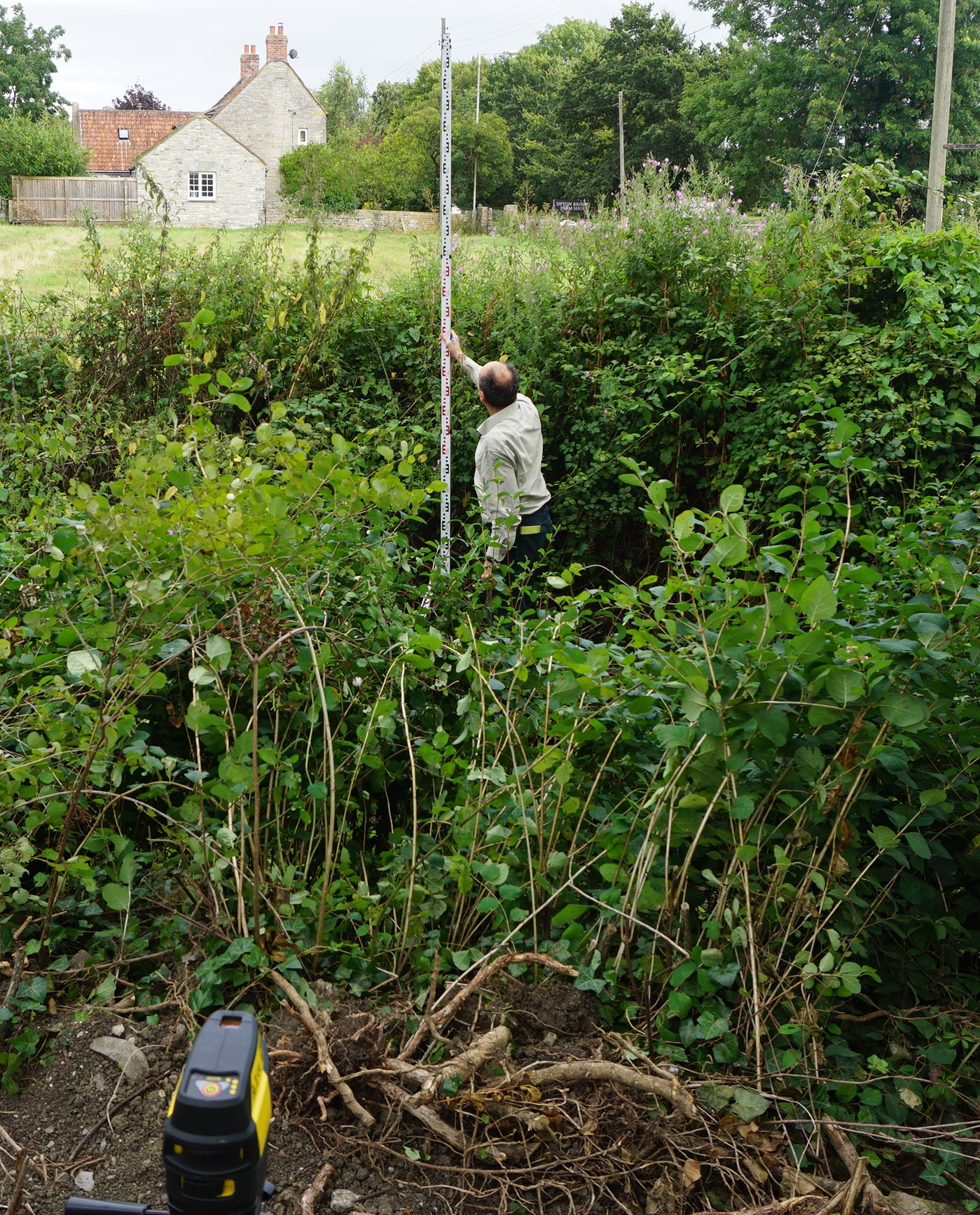 Laser level being used to survey the channel cross-section
